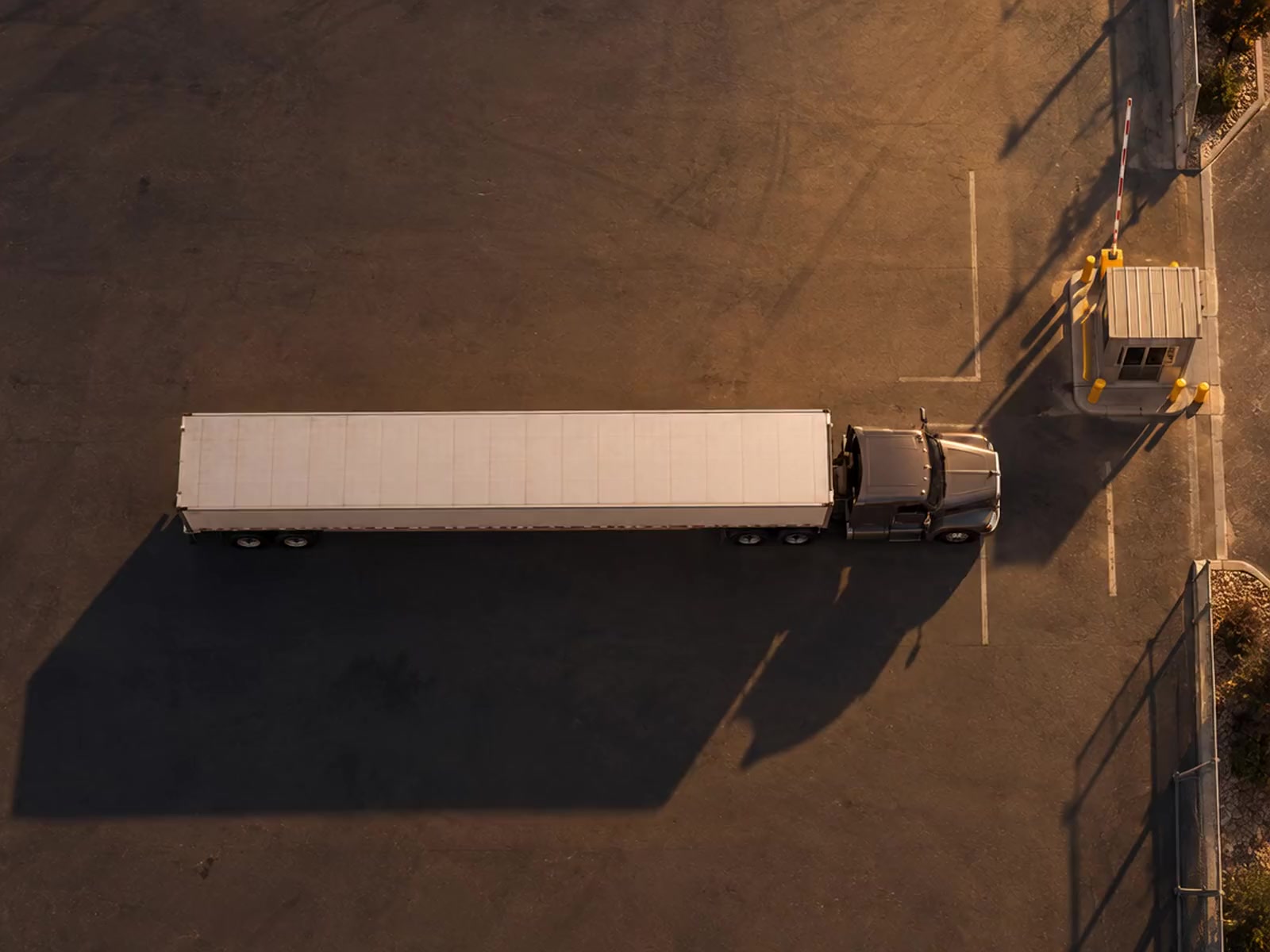An overhead view of a trailer arriving at a warehouse gate.